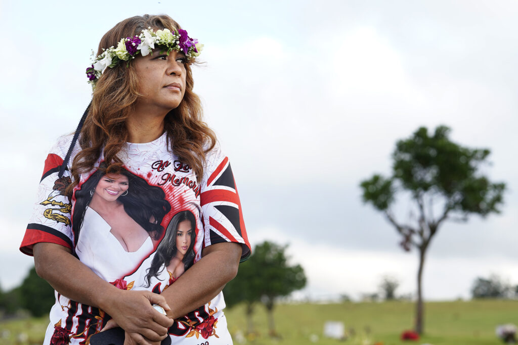 Lucita Ani-Nihoa looks toward her daughter’s best friend Mae Nani Knight at Theresa Cachuela’s grave Sunday, Dec. 15, 2024, at the Mililani Memorial Park and Mortuary in Mililani. The mother and best friend of Theresa invited Civil Beat to visit her gravesite almost one year after she was killed by her estranged husband Jason Cachuela despite a temporary restraining order. (Kevin Fujii/Civil Beat/2024)