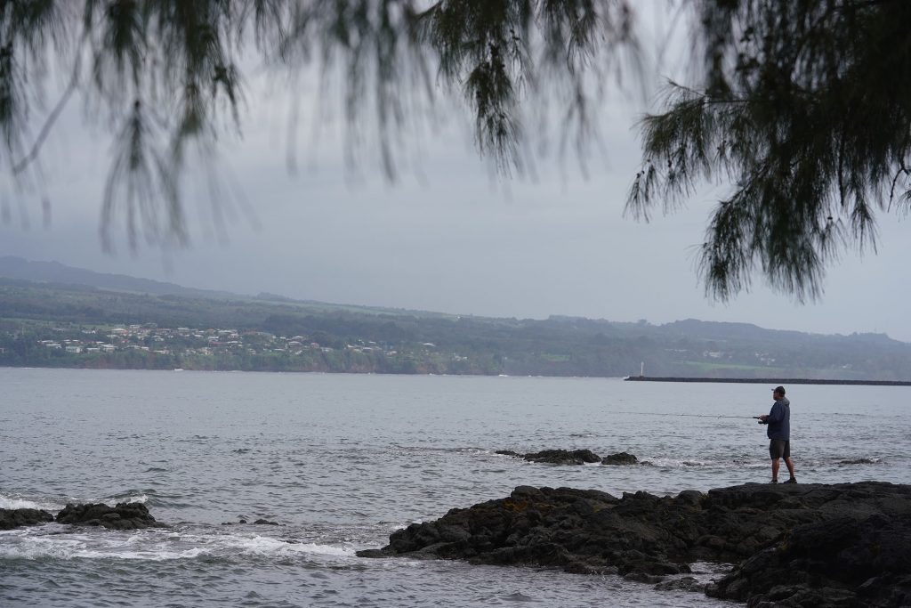 An angler casts off of Coconut Island, HIlo Bay, Hawaii.