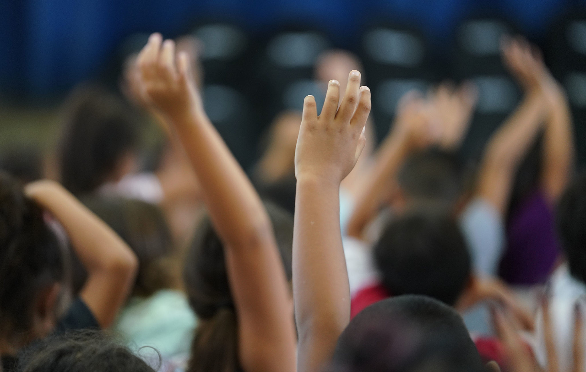Makaha Elementary school raise their hands during an event Servco donated a bunch of backpacks and school supplies.